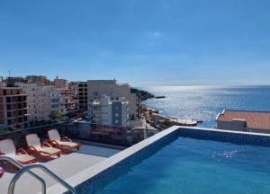 a swimming pool with chairs and a view of the ocean at APARTMENT DZANA in Dobra Voda