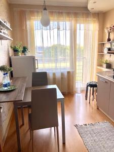 a kitchen and dining room with a table and chairs at Apartment Saharova in Rīga