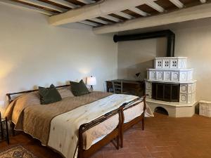 een slaapkamer met een groot bed en een open haard bij Agriturismo Podere Querceto in Borselli