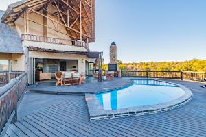 a deck with a swimming pool and a house at Kubu Lodge in Mabula