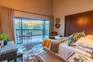 1 dormitorio con 1 cama y balcón en Kubu Lodge en Mabula