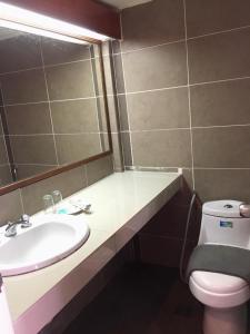 La salle de bains est pourvue d'un lavabo, de toilettes et d'un miroir. dans l'établissement PANORAMA RESORT LANGKAWI, à Kuah