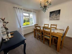 Un comedor con mesa y sillas y una ventana. en Charming 4-Bed House in Cheltenham Free Parking, en Cheltenham