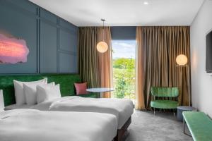 una habitación de hotel con 2 camas y una silla en Tsinandali Estate, A Radisson Collection Hotel en Tsinandali