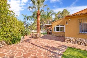 a house with a palm tree and a patio at Bellavista 1016 in Oliva