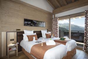 Residence Alpen Lodge في لا روزيير: غرفة نوم بسريرين ونافذة كبيرة