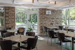 a room with tables and chairs and a brick wall at Palangos Vetra in Palanga +27 photos