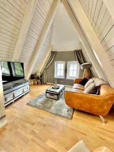 een woonkamer met een bank en een tv bij Gemütliche Maisonettewohnung mit Dachterrasse am Schloß in Oldenburg