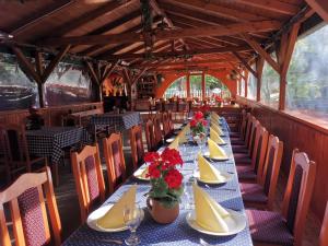 une salle à manger avec une grande table avec des assiettes et des fleurs dans l'établissement Park Hédervár, à Hédervár