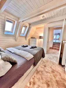 - une chambre avec un grand lit dans une pièce dotée de fenêtres dans l'établissement Gemütliche Maisonettewohnung mit Dachterrasse am Schloß, à Oldenbourg