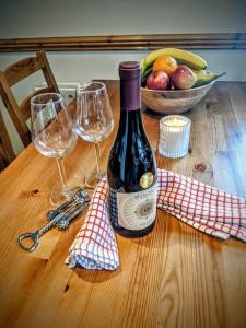 una bottiglia di vino seduta su un tavolo di legno con due bicchieri di Wild Atlantic Haven, cosy home nr. Ballina & Beach 