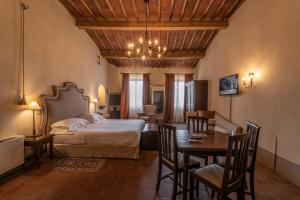 sypialnia z łóżkiem, stołem i krzesłami w obiekcie Palazzo Leopoldo Dimora Storica & Spa w mieście Radda in Chianti