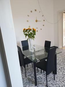 tavolo da pranzo con sedie e vaso di fiori di Angolo Relax Camere king a Rimini
