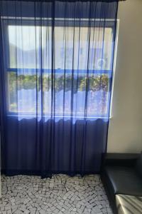 a blue curtain in a room with a window at Angolo Relax Camere king in Rimini