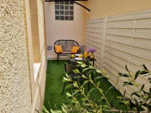 a small patio with a table and chairs on the grass at Maison avec Extérieur - Stationnement Gratuit in Périgueux +5 photos