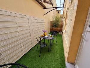 a small patio with a table and chairs on grass at Maison avec Extérieur - Stationnement Gratuit in Périgueux