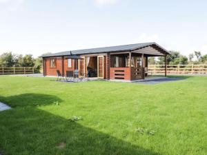 a house with a large yard with a green field at Ty Will, Parc Y Fronwen in Newborough