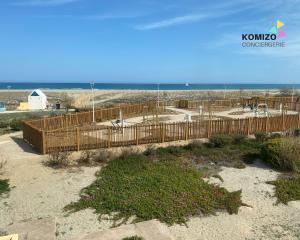 a wooden bridge over a beach with the ocean in the background at L'Aigrette - Front de mer-Accès direct plage in Port Leucate