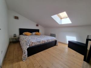 ein Schlafzimmer mit einem Bett und einem Dachfenster in der Unterkunft Maison avec Extérieur - Stationnement Gratuit in Périgueux