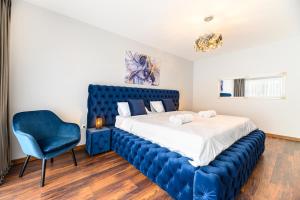 a bedroom with a blue bed and a blue chair at High Comfort Brasov in Braşov