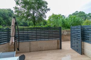 a fence with an umbrella on a patio at LUXURY SILGAR in Sanxenxo