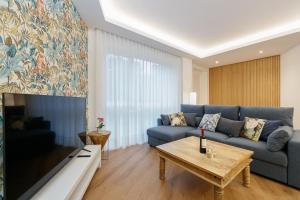 a living room with a blue couch and a table at LUXURY SILGAR in Sanxenxo