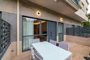 a patio with a white table and chairs on a balcony at LUXURY SILGAR in Sanxenxo