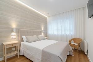 a bedroom with a white bed and a window at LUXURY SILGAR in Sanxenxo