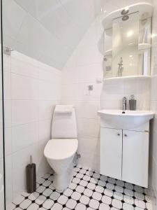 a white bathroom with a toilet and a sink at Villa Marienholm in Haapsalu