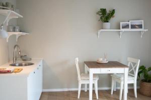 a kitchen with a table and two chairs and a sink at 1-Zimmer-Appartement, beste Lage in Oberkotzau +11 photos