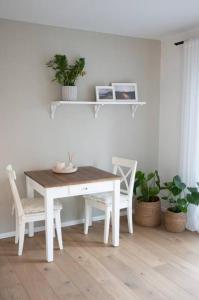 a white dining room table with two chairs and plants at 1-Zimmer-Appartement, beste Lage in Oberkotzau