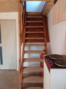 a wooden staircase in a kitchen with a stove at Domek letni in Pozezdrze