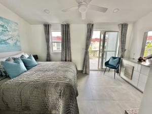 a bedroom with a large bed and a blue chair at Mild Sunshine in Jolly Harbour