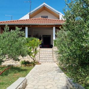a house with a pathway in front of it at Holiday House DA & DO in Pakoštane