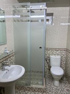 a bathroom with a shower and a toilet and a sink at Hotel Shakhname in Samarkand