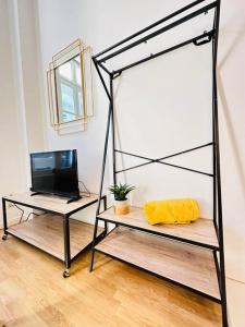 a room with two shelves with a television and a television at Studio chaleureux in Laon