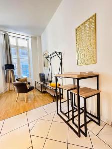 ein Wohnzimmer mit einem Tisch und einem Stuhl in der Unterkunft Studio chaleureux in Laon