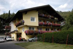 a yellow building with flower boxes on it at Pension & Appartement Fortin in Bad Kleinkirchheim