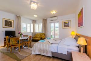 a bedroom with a bed and a desk and a table at Apartments & Rooms V&M in Dubrovnik