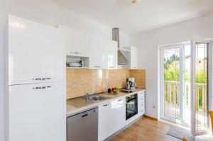 a kitchen with white appliances and a large window at Apartments & Rooms V&M in Dubrovnik