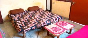 a table with a quilt and a chair in a room at Shri Homes in Varanasi