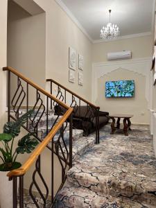 サマルカンドにあるHotel Shakhnameのリビングルーム(階段、テーブル付)