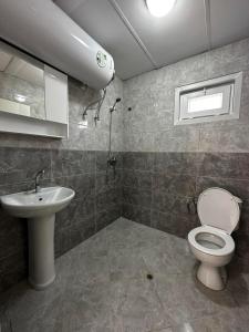 a bathroom with a toilet and a sink at Къщички Sunrise in Tsarevo