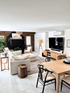 ein Wohnzimmer mit Möbeln und einem Flachbild-TV in der Unterkunft Sunset on Noosa Chalet in Noosa Heads
