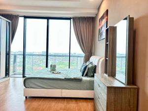 a bedroom with a bed and large windows at Jeff and Ricky Homestay 8 Boulevard Imperial Suites in Kuching