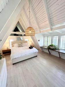 a large bedroom with a white bed in a attic at Sunset on Noosa Chalet in Noosa Heads