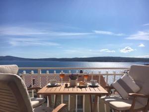 a table on a balcony with a view of the water at Apartment Araucaria Gallery in Crikvenica