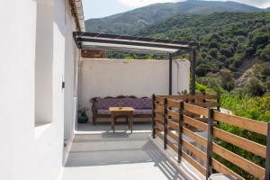 a patio with a purple couch and a table at Casa Elafonisi N2-10min from the beach in Plokamianá