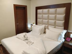a bedroom with a bed with white sheets and pillows at Hotel Yatrik in Jhānsi