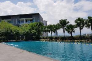 uma piscina em frente a um edifício com palmeiras em Mountain City View @ THE LOFT IMAGO, 2bedroom 5pax em Kota Kinabalu